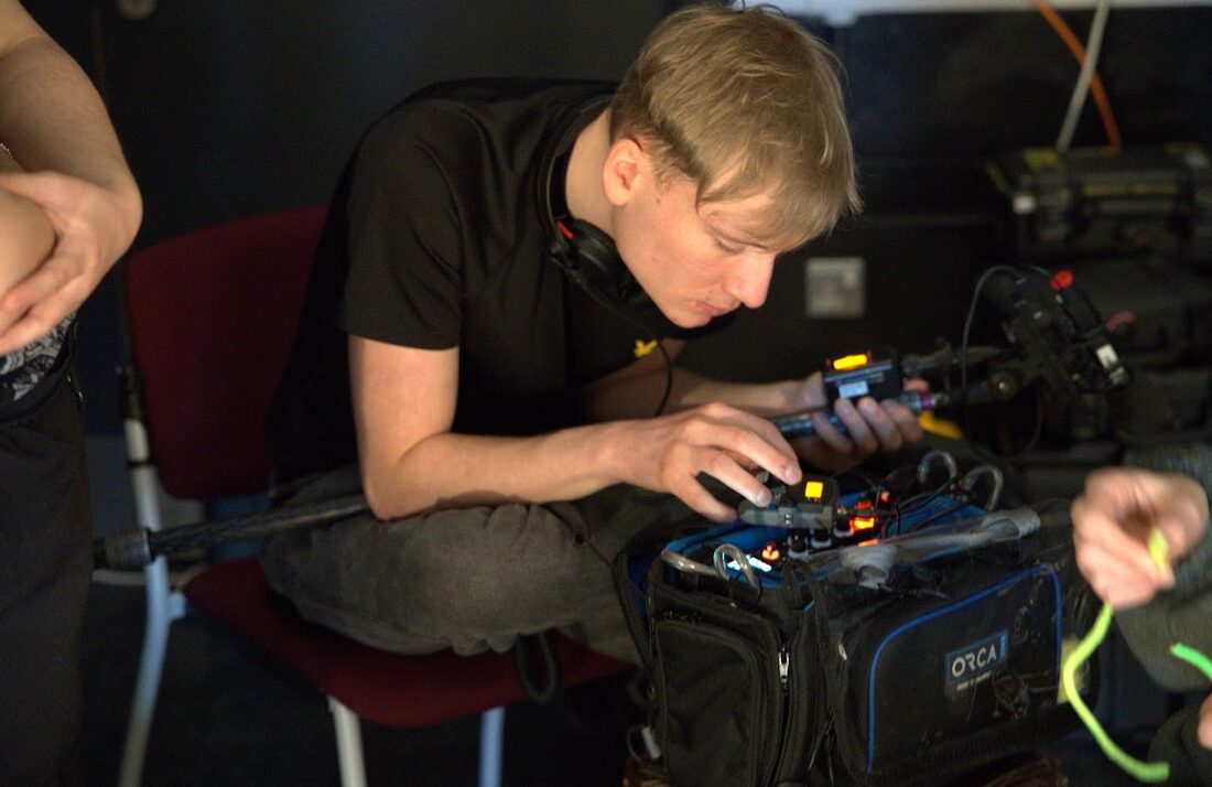 Daniel Friend monitoring a field recorder on location